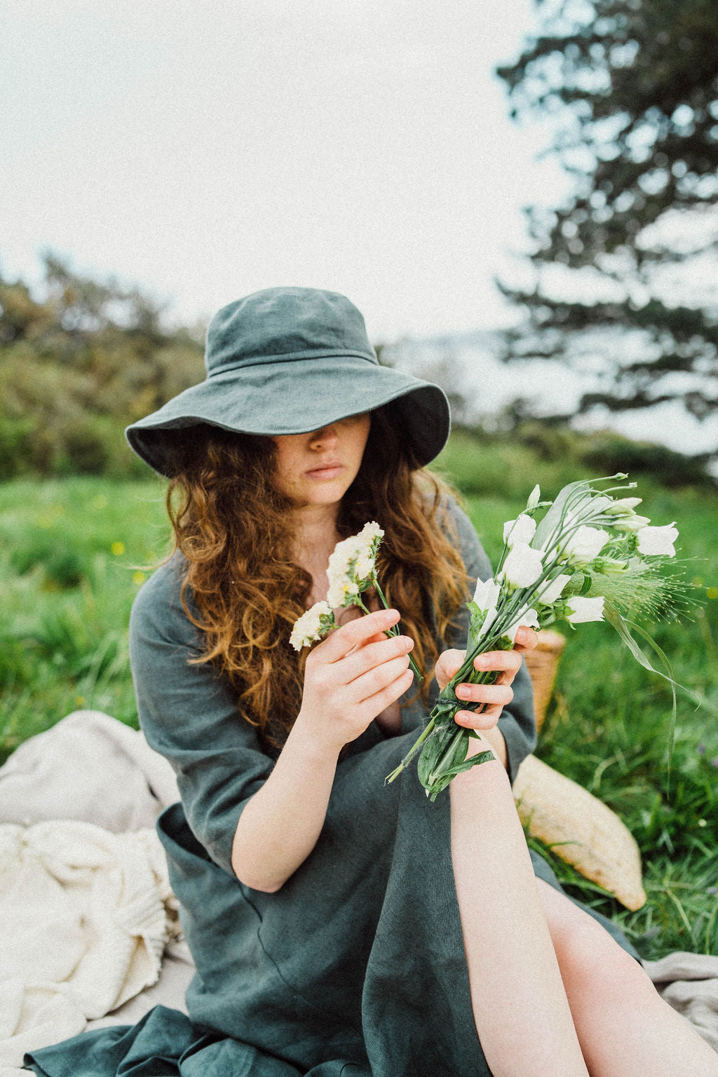 Solpardus in wild meadow for picnic. Nyx linen hat Delphi linen dress. All natural ethical sustainable sunwear swimwear linen clothing perfect for sensitive skin psoriasis and eczema