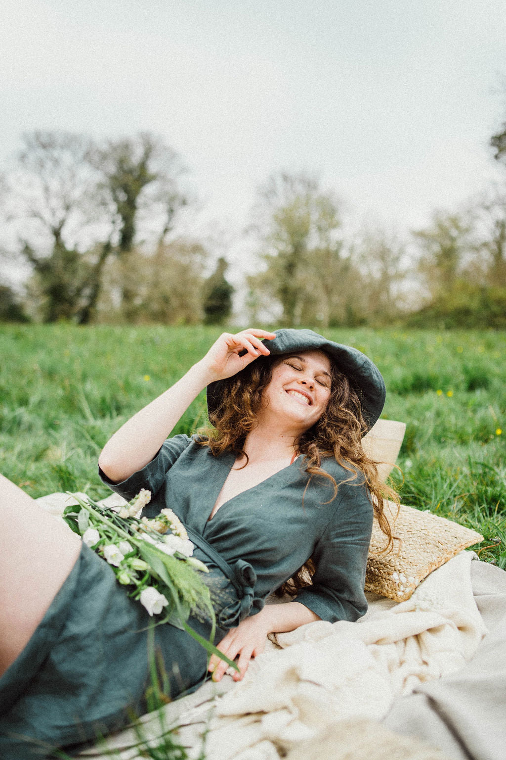 Solpardus picnic in Mawnan Smith Cornwall in field with wild flowers. Delphi linen dress Nyx linen hat. All natural ethical sustainable linen clothing perfect for sensitive skin psoriasis and eczema