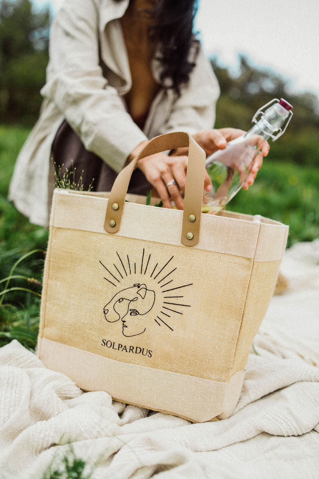 Solpardus ‘Everything’ bag. Jute and juco bag with buffalo leather handles, brass feet and premium flock heat transfer to give the Solpardus logo a luxurious velvet texture. On picnic blanket in Cornwall