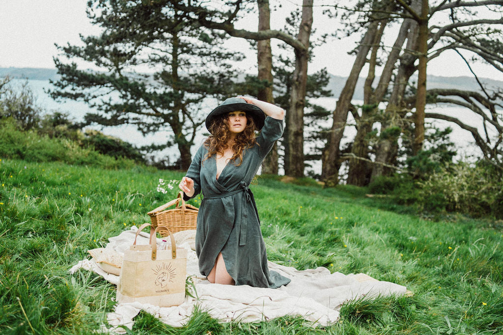 Solpardus picnic in Delphi linen dress. Grass in Mawnan Smith Cornwall. Delphi linen dress Nyx linen hat. All natural ethical sustainable sunwear linen clothing perfect for sensitive skin psoriasis and eczema